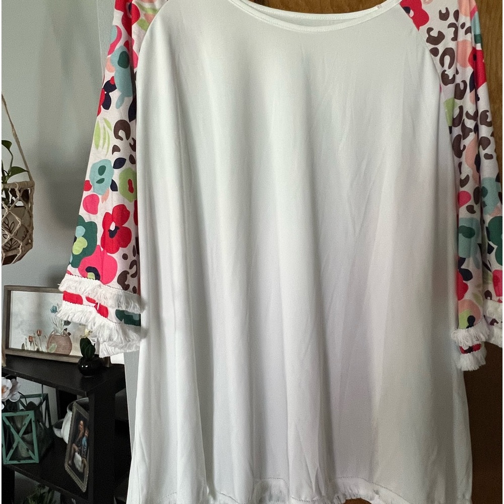 Pretty white top with colorful flowered short layered sleeves. With fringe